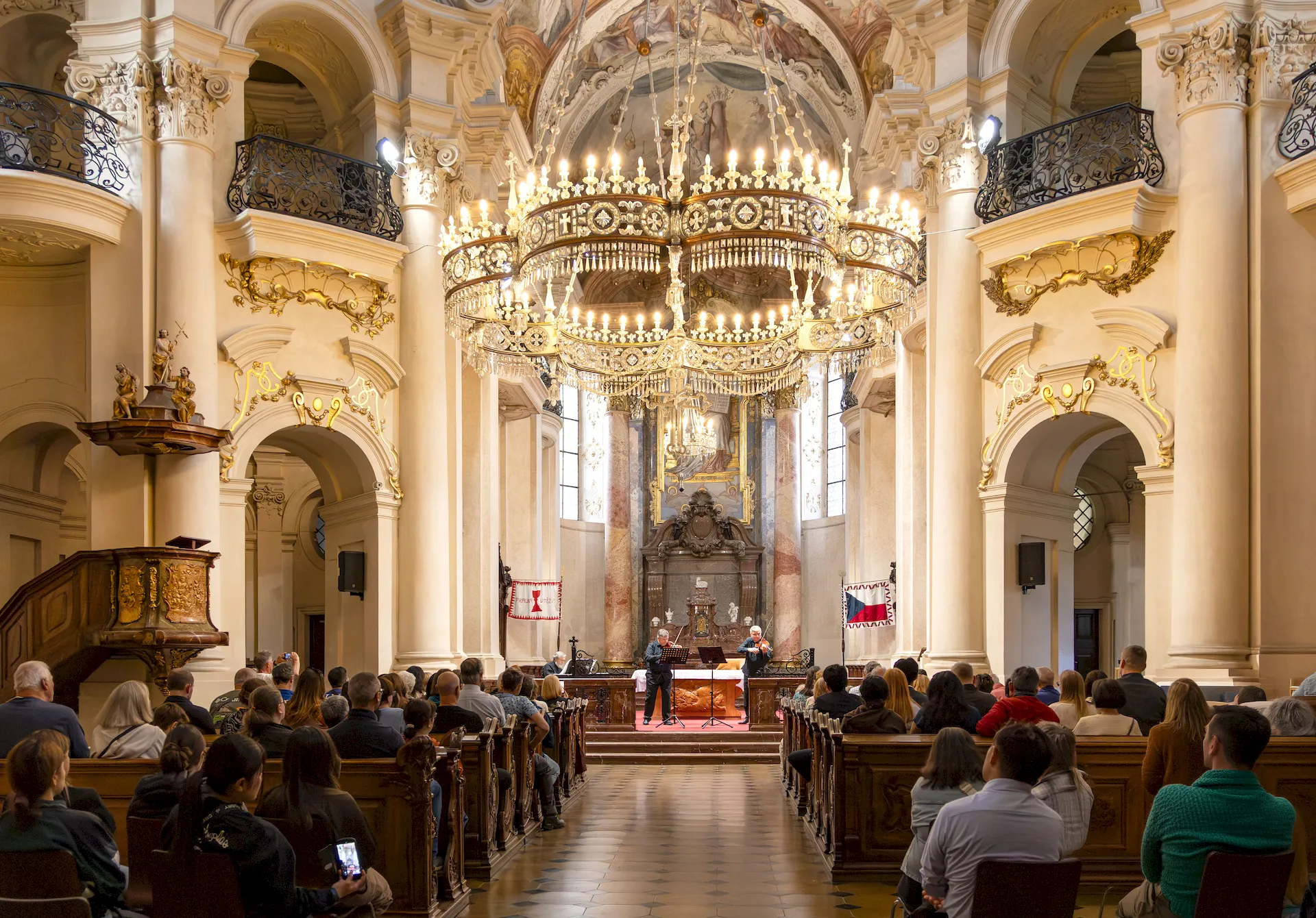 Classical concert with an audience in the Baroque interior of Kostel sv. Mikuláše in Prague