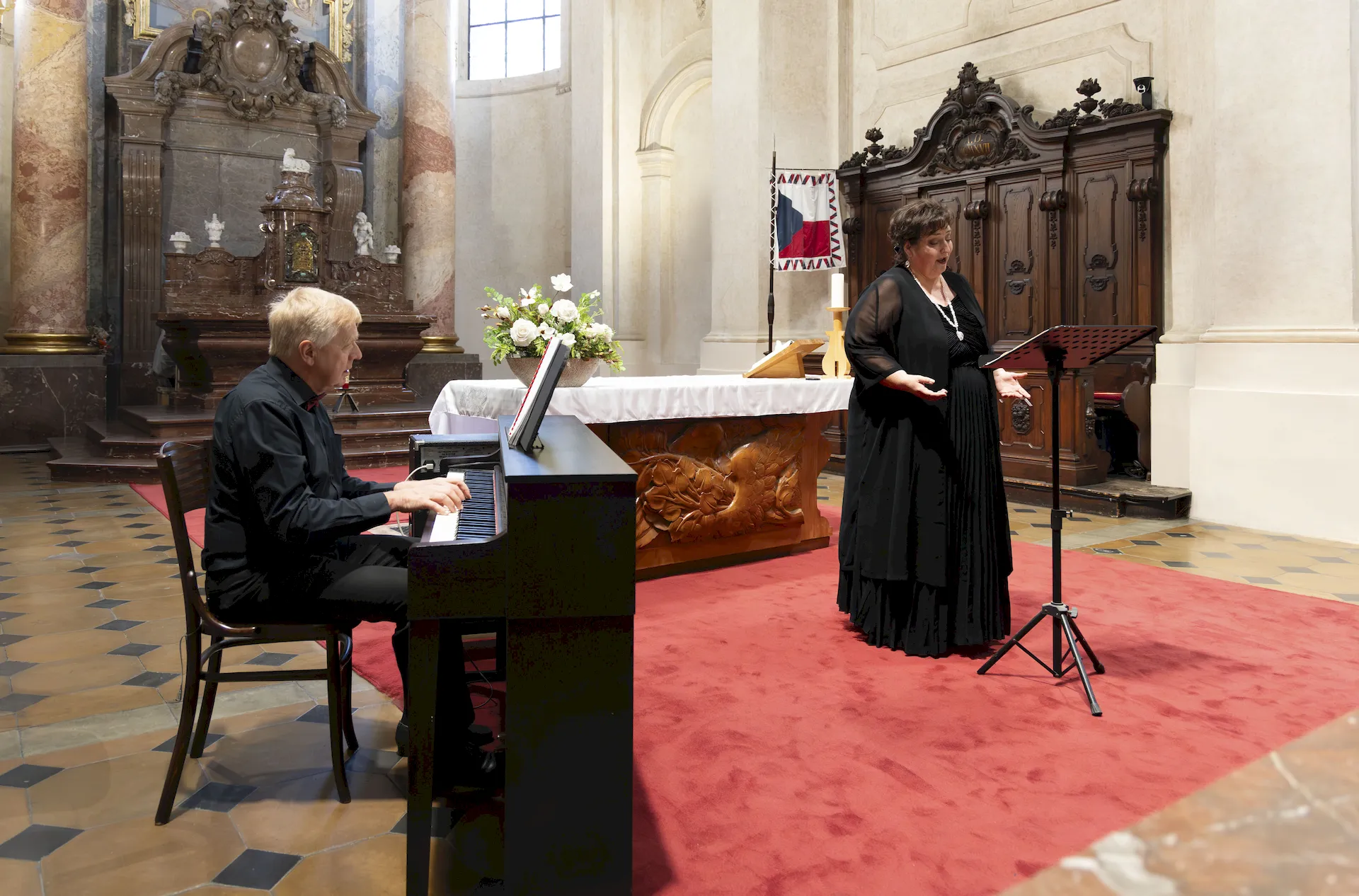 Yvona Škvárová and Jan Kalfus performing close to the audience in Kostel sv. Mikuláše
